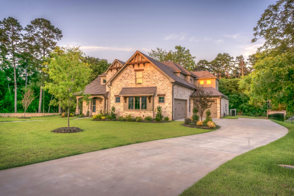 pexels-photo-259588-259588-1 Elegant stone family home surrounded by trees, lush lawn, and vibrant garden.